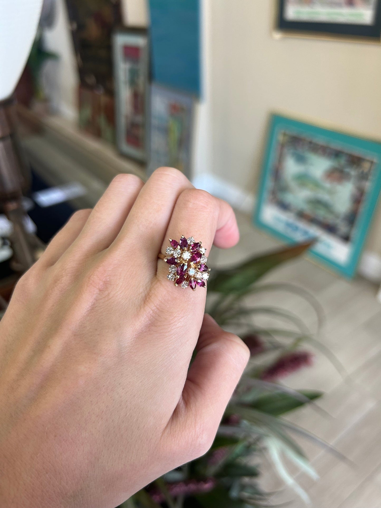 a woman's hand holding a pink and white ring