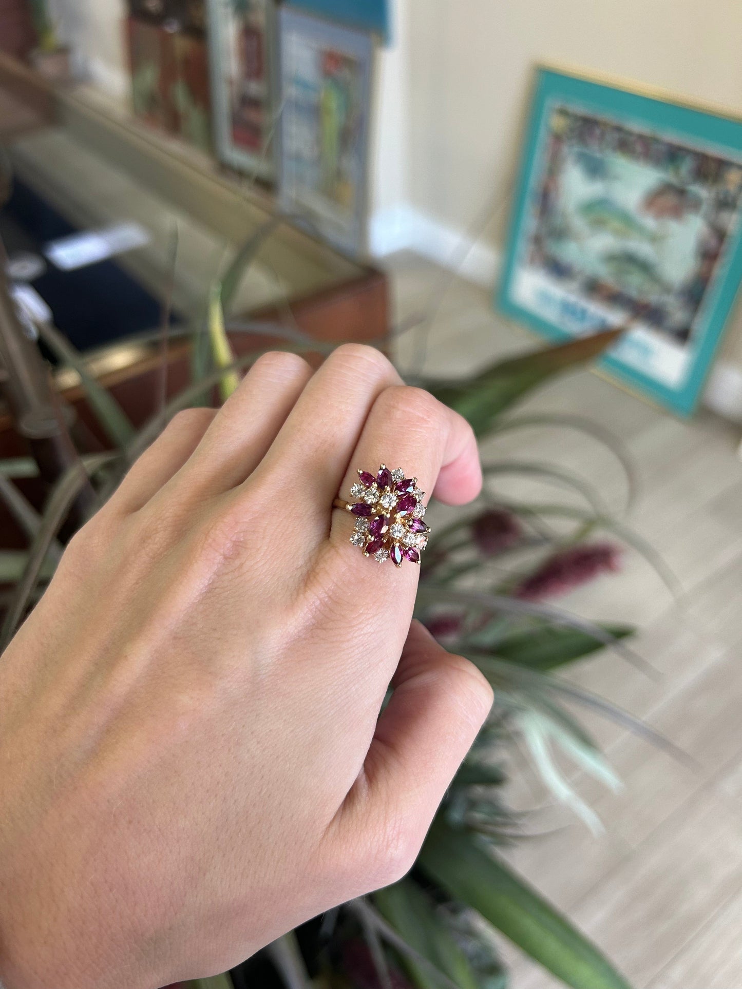 a person's hand holding a ring with a flower on it