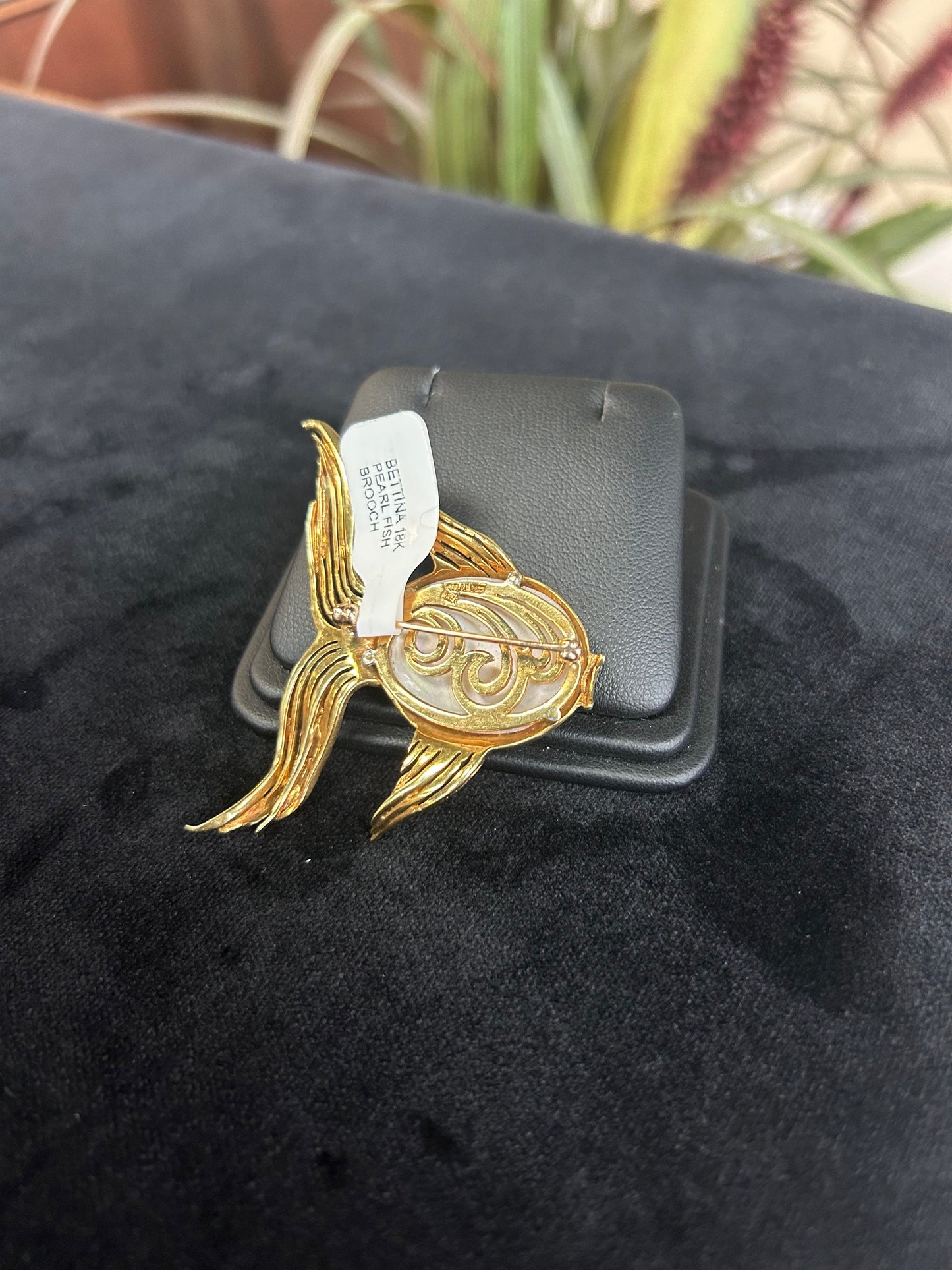 a black jacket with a gold brooch on it