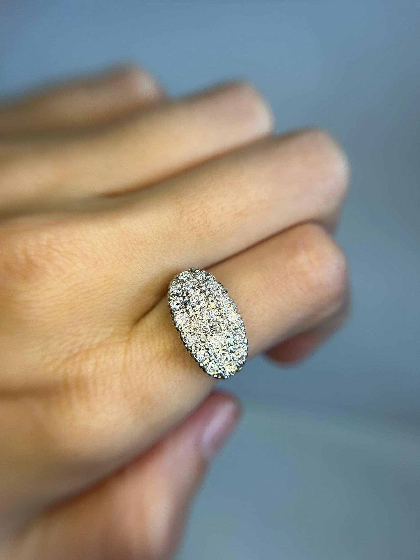 a close up of a person's hand holding a diamond ring