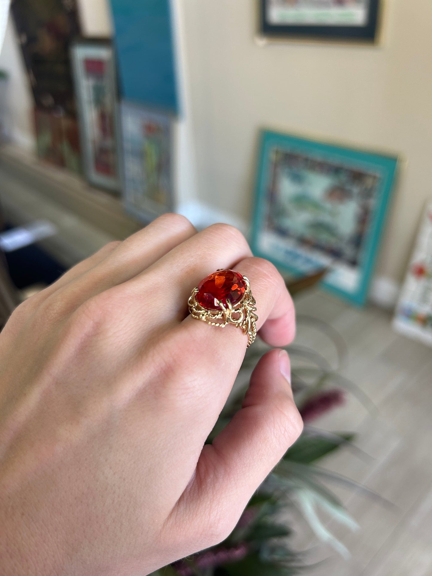a person holding a ring with a red stone in it