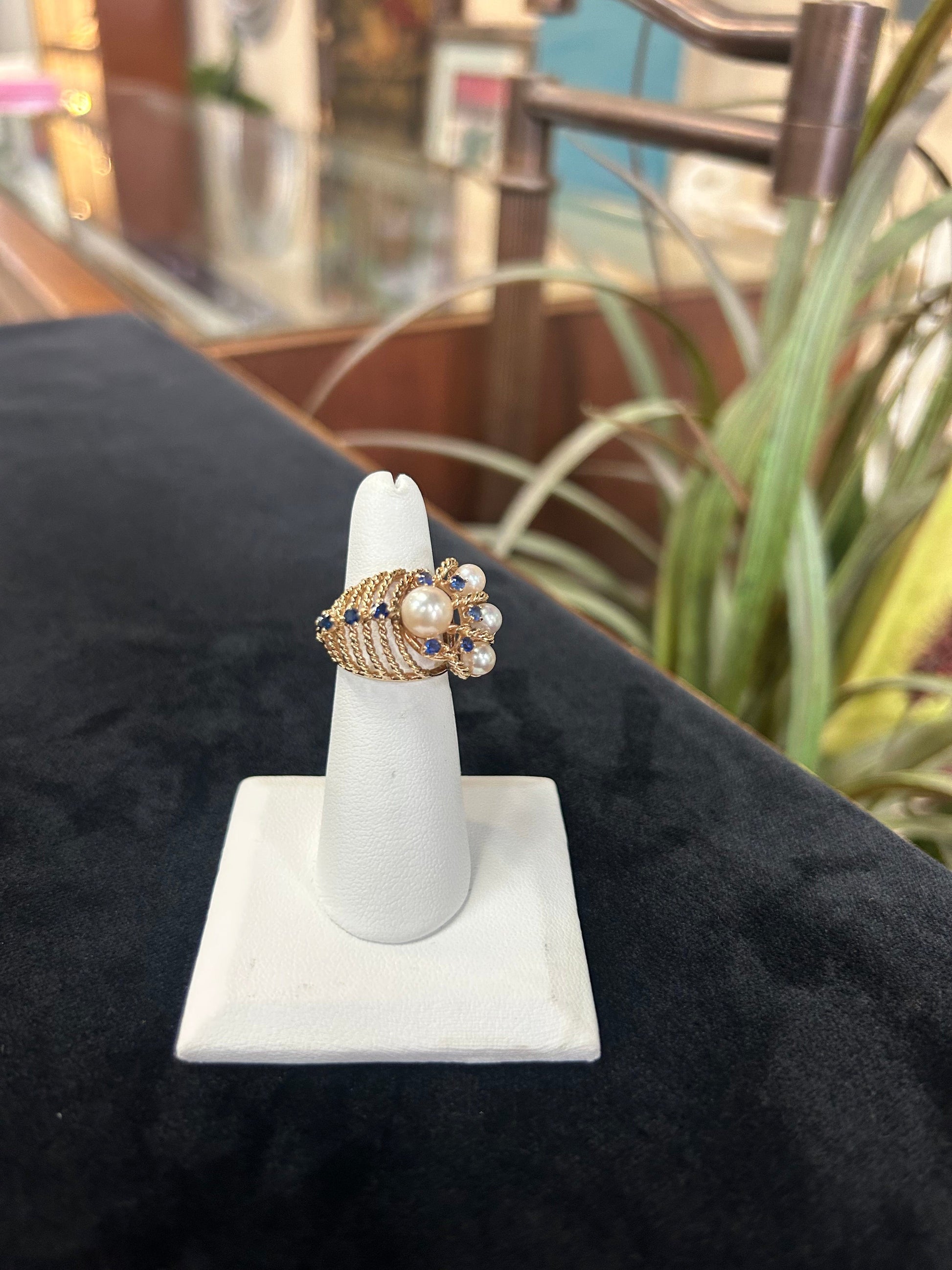 a ring with pearls on it sitting on a stand