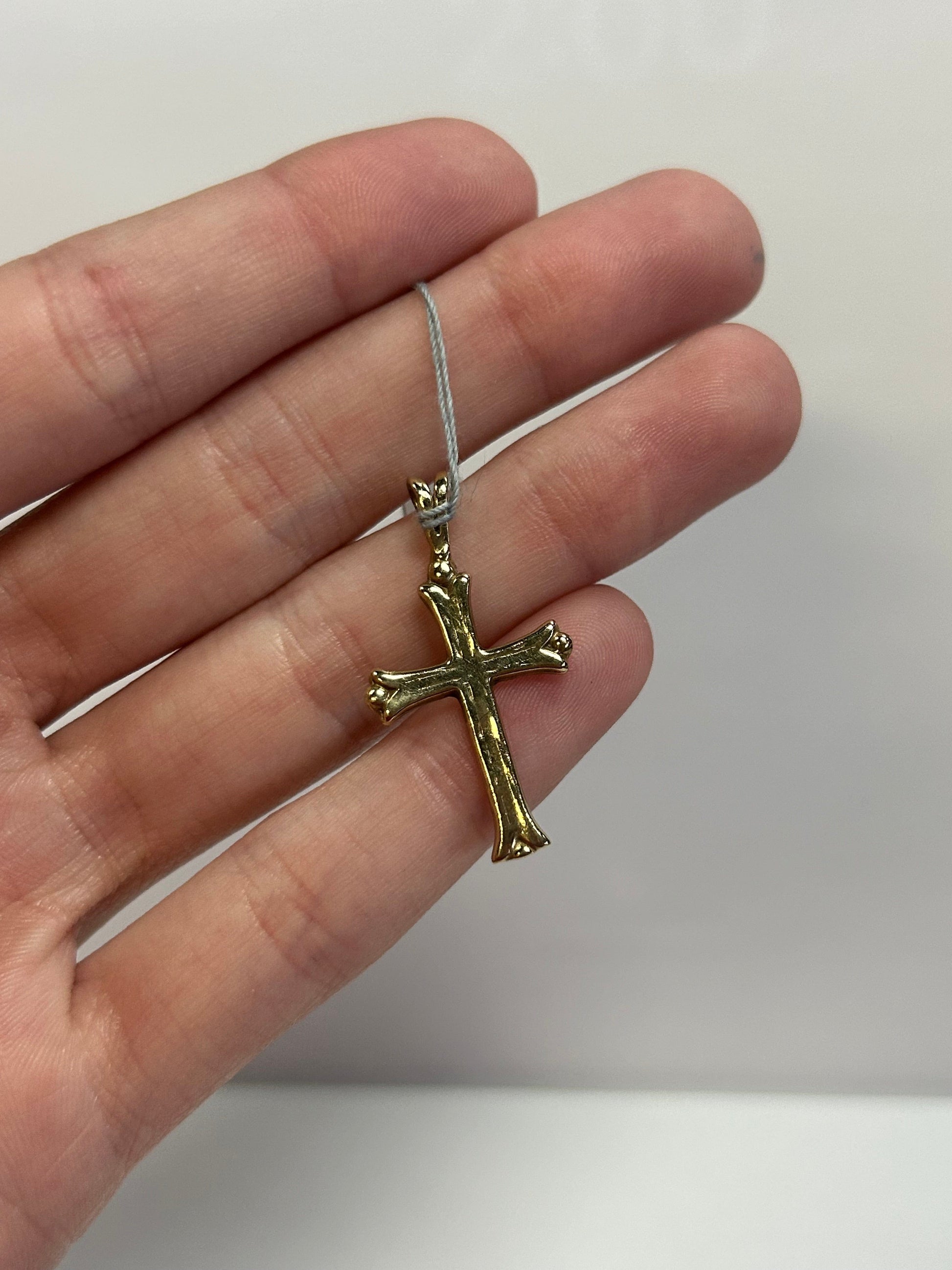a person holding a small cross in their hand
