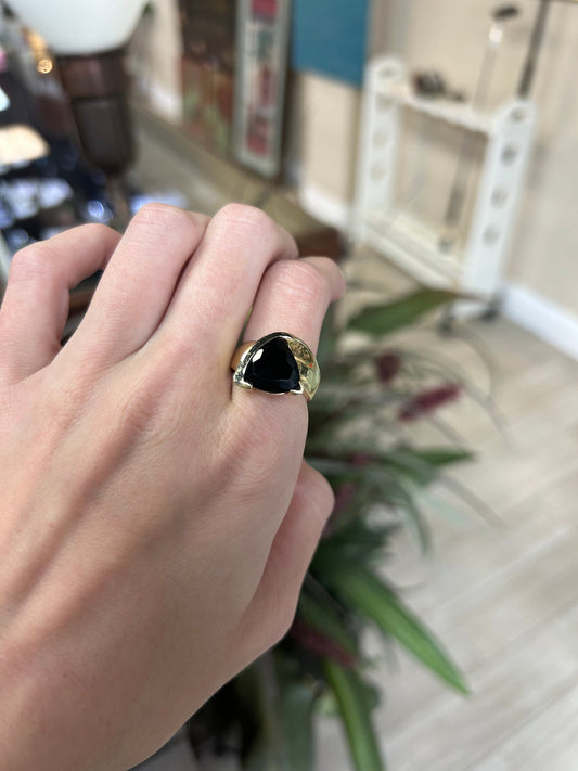 a person wearing a ring with a black stone