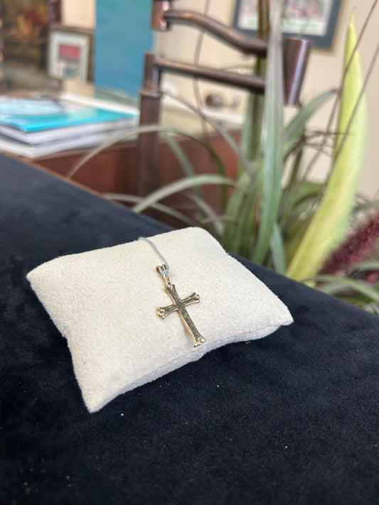 a ring with a cross on it sitting on a pillow